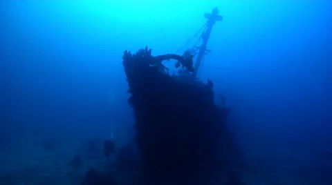 Ocean scenery one diver under bow, another up in the rigging, on deep coral Stock Footage 62215511
