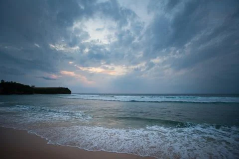 Ocean shore during sunset with cloudy sky Stock Photos