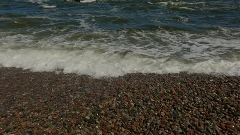 Ocean shore with rolling waves and pebbles, details of powerful ocean wave Stock Footage 295765593