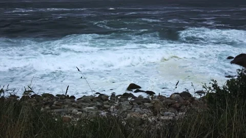 The ocean shore is strong in a storm. The waves beat against the rocky shore Stock Footage 230280573