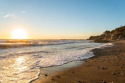 Ocean shore at sunset Stock Photos