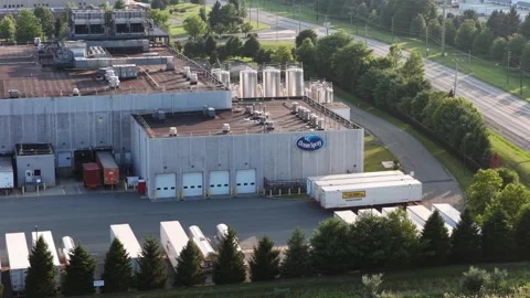 Ocean Spray logo marks large concrete building beside rooftop storage tanks and Stock Footage 340970797
