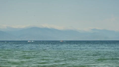 Ocean stretching toward hazy mountain range Stock Footage 341765669