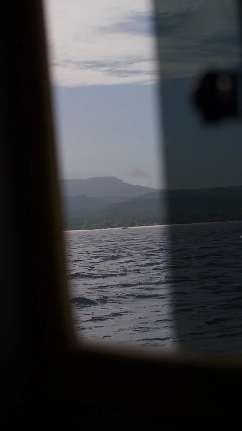Ocean on a sunny day through the window of the boat. Vertical video. Stock Footage 250608721