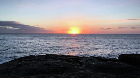 Ocean sunrise with black lava cliffs in silhouette (4K) Stock Footage 61152448