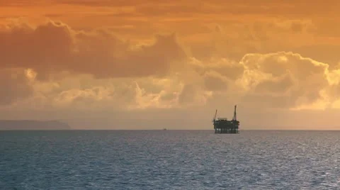 Ocean sunset - oil rig drilling platforms on horizon Stock Footage