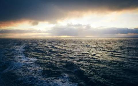 Ocean Sunset with Storm Clouds and Dramatic Waves Stock Photos