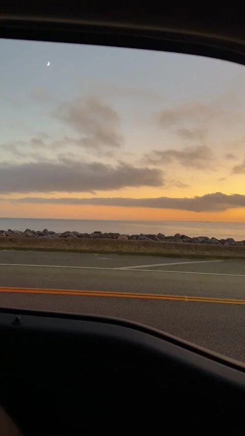 Ocean sunset view from car window driving along California coast Stock Footage 320017148