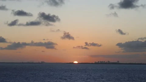Ocean sunset viewed from moving ship on the sea with distant city skyline Stock Footage 172873741