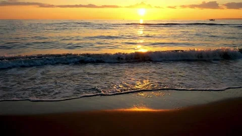Ocean sunset waves rolling onto sandy beach with golden sun reflection. Stock Footage 341395222