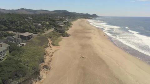 Ocean surf, beach, and beach houses near Depoe Bay Oregon Stock Footage 246834147