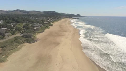 Ocean surf, beach, and beach houses near Depoe Bay Oregon Stock Footage 246834697