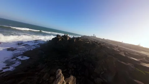 Ocean surf crashes against dark volcanic cliffs Video stock 346076698