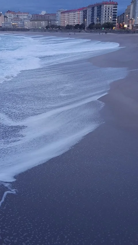 Ocean surf on the sandy beach of the night city Stock Footage 236644214