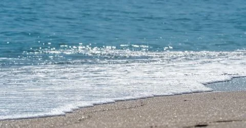 Ocean surf on the sandy beach Stock Photos