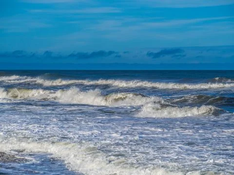 Ocean surf at sandy beach Stock Photos