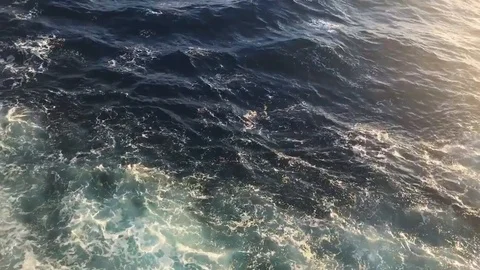 Ocean surface motion wake waves sunlight Stock Footage 97179504