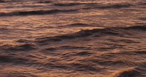 Ocean surface sways, refracting orange sunset Stock Footage 240284740