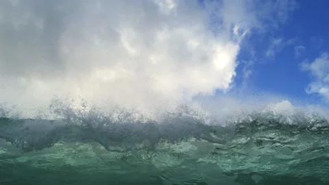 Ocean Swell Rolling Beneath Towering White Clouds and Blue Sky Stock Footage 344386714