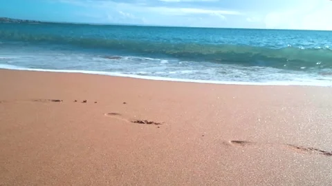 Ocean Tide Erasing Human Footprints from Sandy Beach Stock Footage 334036936