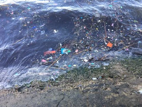 Ocean Trash Pollution Garbage Floating waves on beach Stock Photos