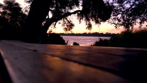 Ocean view and light sea breeze during sunset over picnic table. Stock Footage 274460236