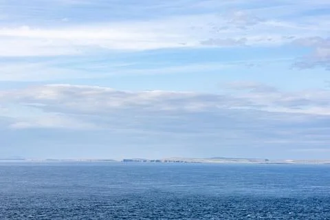 Ocean View with Distant Cliffs Under Cloudy Sky Stock Photos