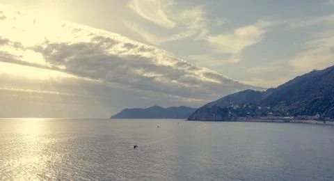Ocean view with evening sun illuminating curvy coastline. Stock Photos