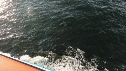 Ocean view from a moving boat, waves splashing against the hull under sunlight Stock Footage 294374733
