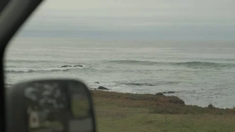 Ocean view reflected in car side mirror along coastal highway Stock Footage 345167967
