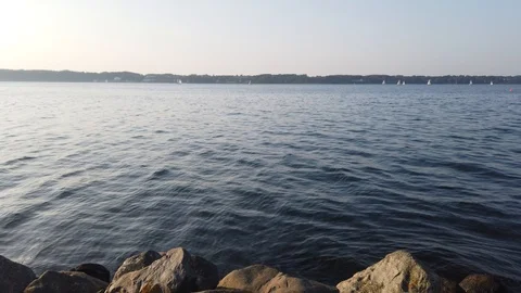 Ocean view from the shore with smooth waves hitting the stones 스톡 동영상 115106183