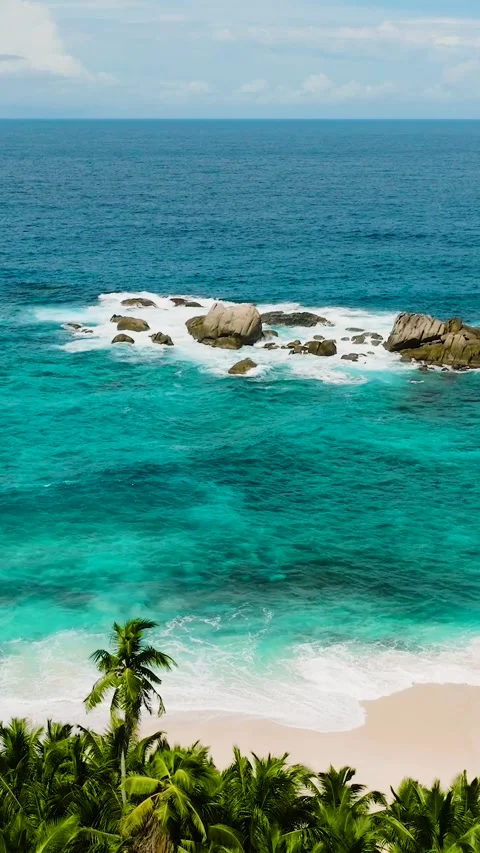 Ocean view with turquoise water and scattered rocks near the coast. Seychelles Stock Footage 303390677