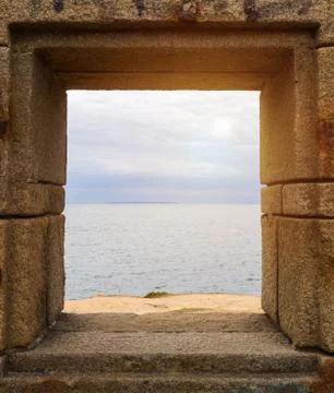 Ocean viewed through window of stone wall Foto stock