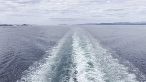 Ocean Wake Trail with Distant Fjords Under Blue Cloudy Sky Stock Footage 340108522
