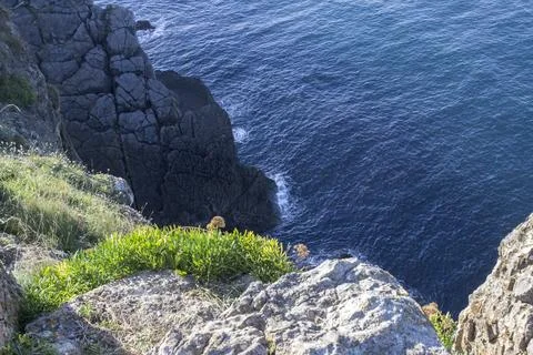 The ocean washes the cliffs with its waves. Stockfoto's