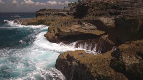 Ocean water breaks on rocks on bright sunny day Stock Footage 108792910