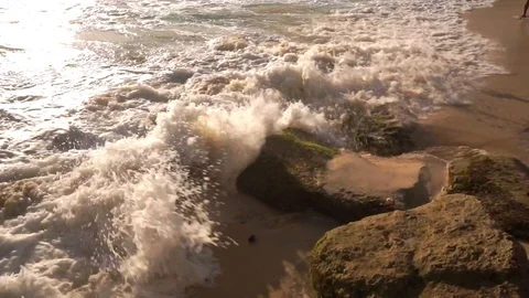 Ocean water breaks on rocks on bright sunny day Stock Footage 108793631