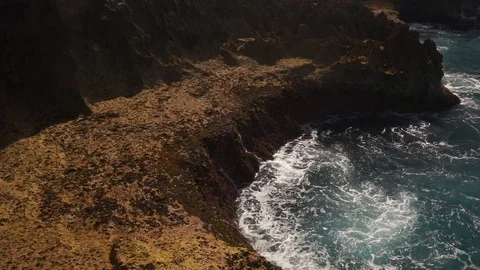 Ocean water breaks on rocks on bright sunny day Stock Footage 108794497