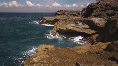Ocean water breaks on rocks on bright sunny day Stock Footage 108796331
