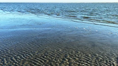 Ocean water creating abstract art on the sand Stock Footage 231162927