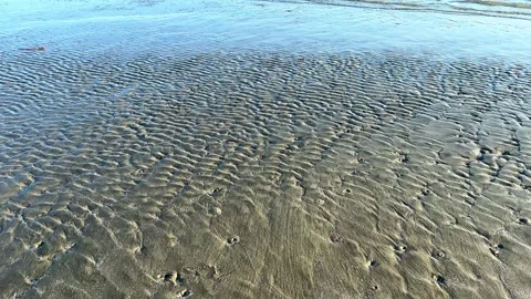 Ocean water creating abstract art on the sand Stock-Footage 231162991