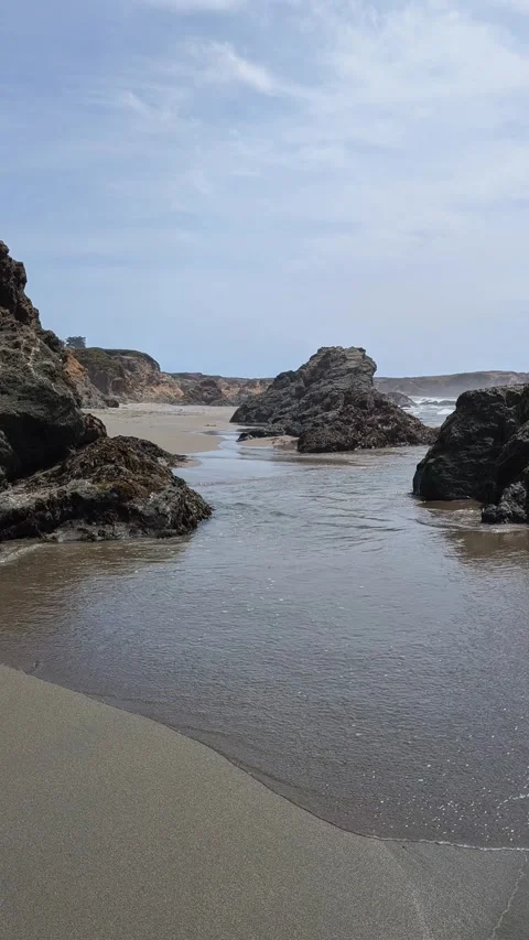 Ocean water flows between rugged rock formations on a Northern California beach Stock Footage 333347306