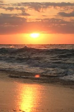 Ocean wave on the beach at sunset 스톡 사진