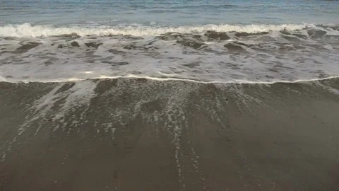Ocean wave breaks at sandy beach, 16x 480 fps slow motion Stock Footage 86272942
