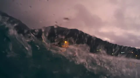 Ocean wave breaks on the shore at twilight. Wave rolls at windy sunset at Vidéo 153521018