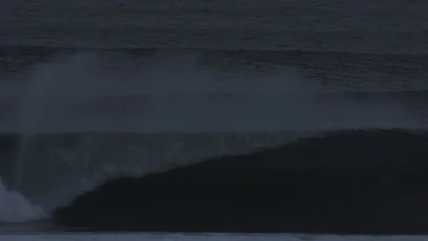 Ocean wave builds and rolls left under gray overcast light Video stock 312660733