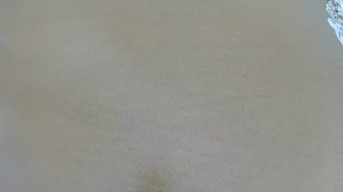 Ocean wave crashes over sandy beach from the side in a fisheye wide perspective Stockbeeldmateriaal 98428088