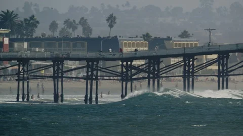 Ocean wave crashes into a pier on a hot summer day Vídeo Stock 119041352