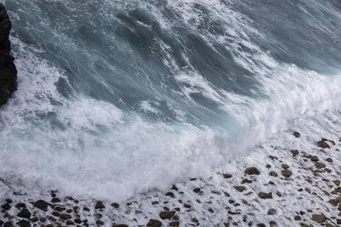 Ocean wave crashing on rocks generating foam 库存照片