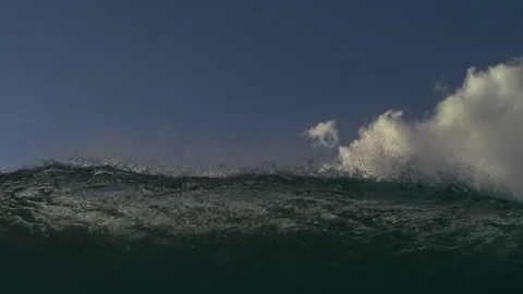 Ocean Wave Crest Rising Against Blue Sky and White Clouds Stock Footage 344387053